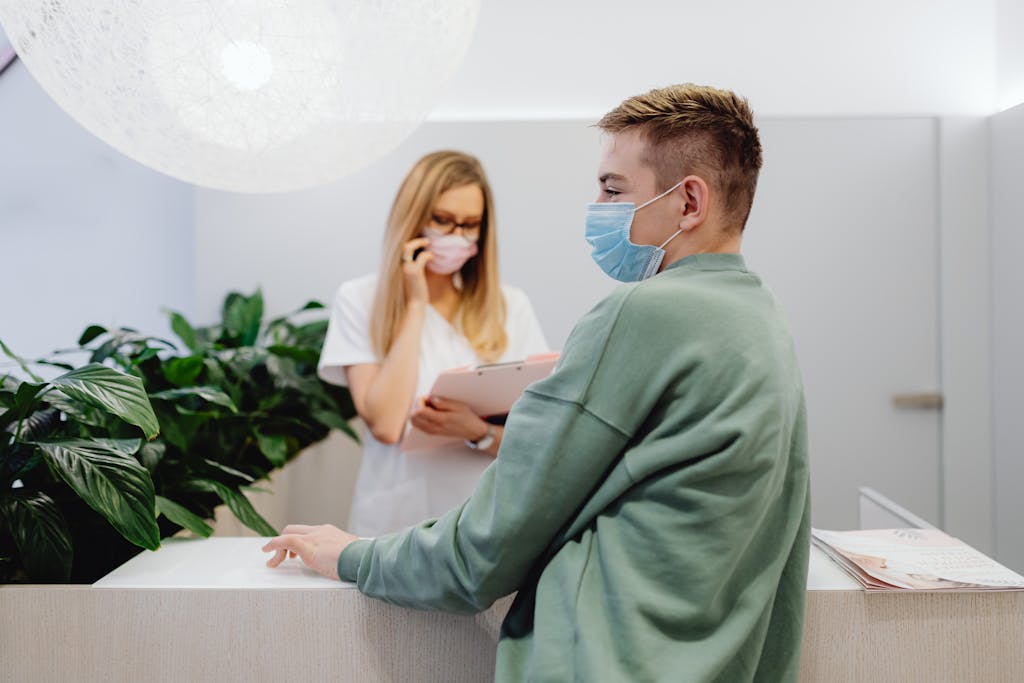 Patient in Face Mask at Reception in Hospital